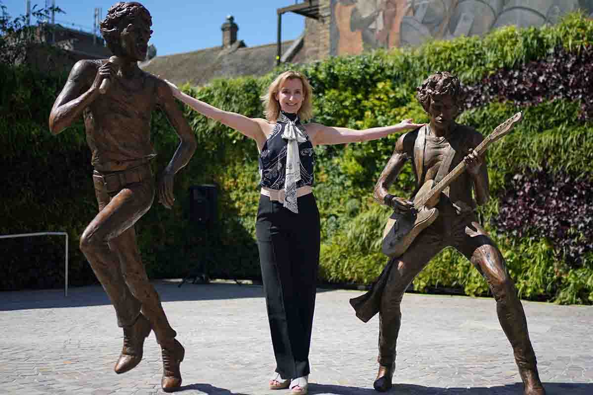 La scultrice Amy Goodman tra le due statue di Jagger e Richards