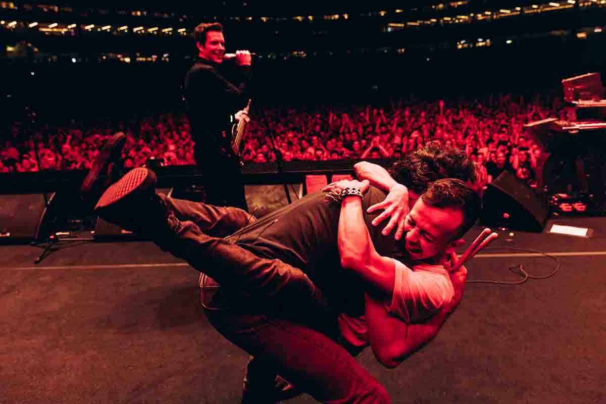 Uno dei fan che ha suonato la batteria con la band abbraccia Ronnie Vannucci